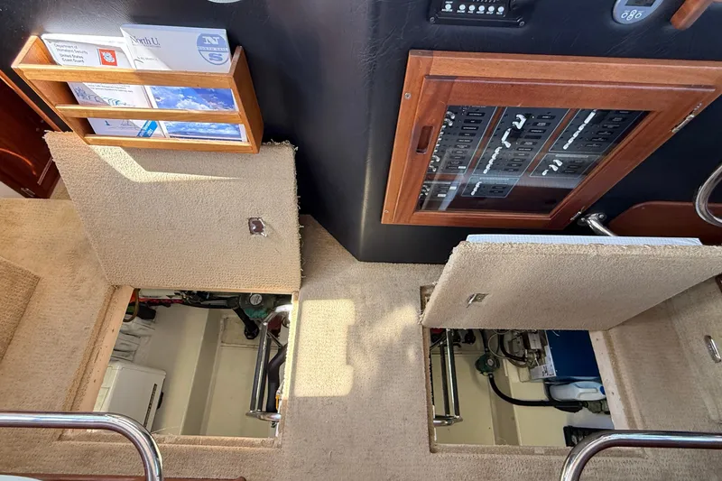 Slide: The Image of Engine room access on 2012 American Tug 365 with control panel and manuals. - 142