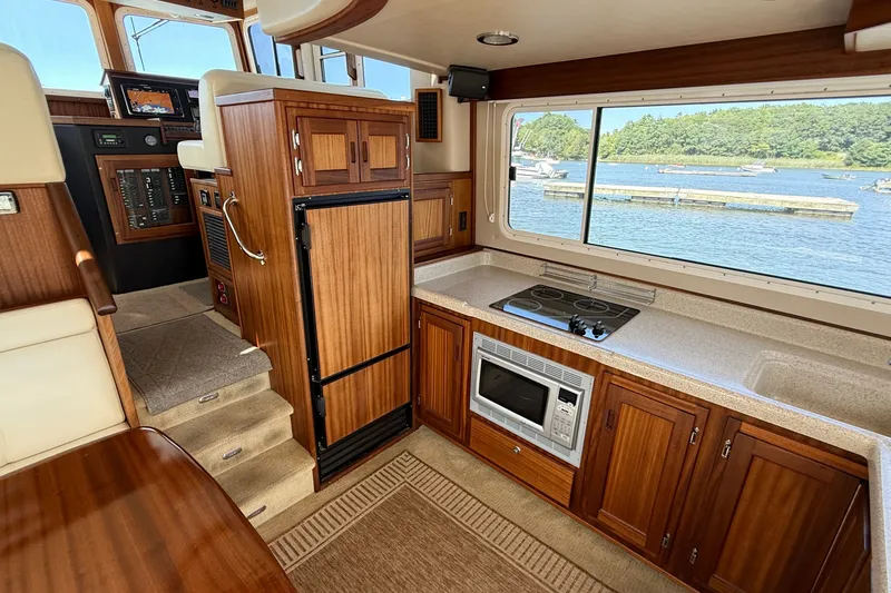 Slide: The Image of Interior of 2012 American Tug 365 with kitchen, wood cabinetry, and waterfront view. - 49