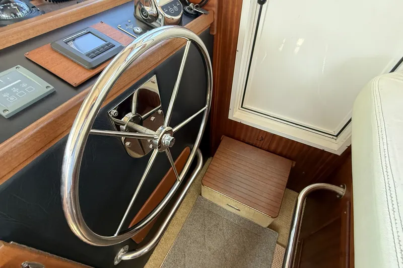 Slide: The Image of Steering wheel and controls of a 2012 American Tug 365 boat interior. - 92
