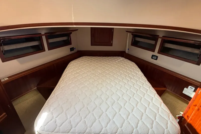 Slide: The Image of Cozy cabin interior of 2012 American Tug 365 with a comfortable bed and wooden accents. - 116