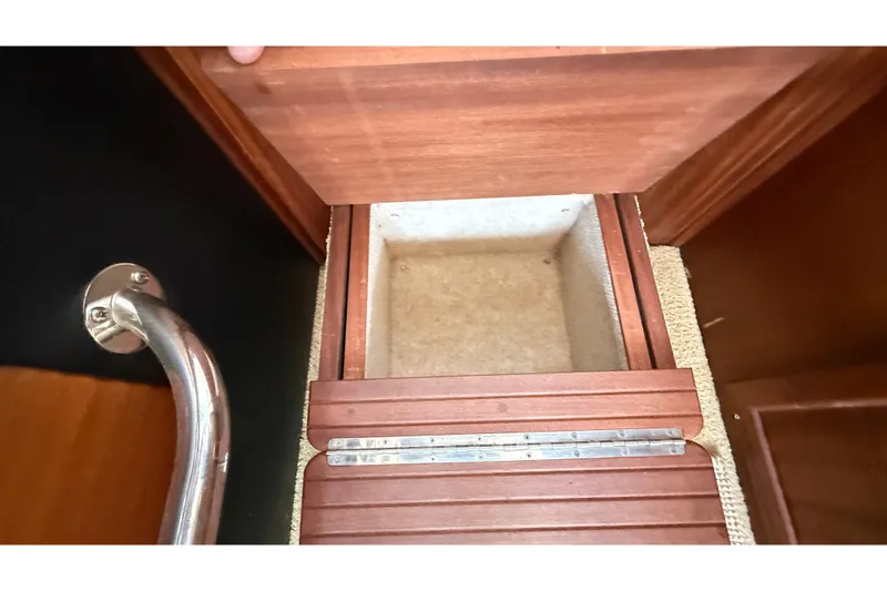 Slide: The Image of Storage compartment in 2012 American Tug 365 boat with wooden finish and metal handle. - 94