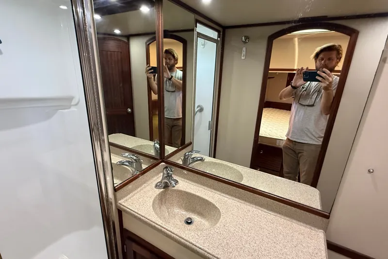 Slide: The Image of Bathroom interior of 2012 American Tug 365 with mirrored cabinets and sink. - 133