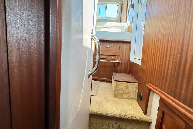 Slide: The Image of Interior view of 2012 American Tug 365 with wooden paneling and carpeted steps. - 135