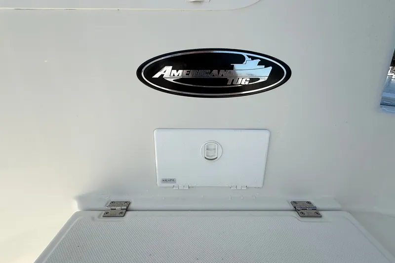 Slide: The Image of American Tug 365 emblem on a 2012 model boat, featuring a storage compartment. - 34
