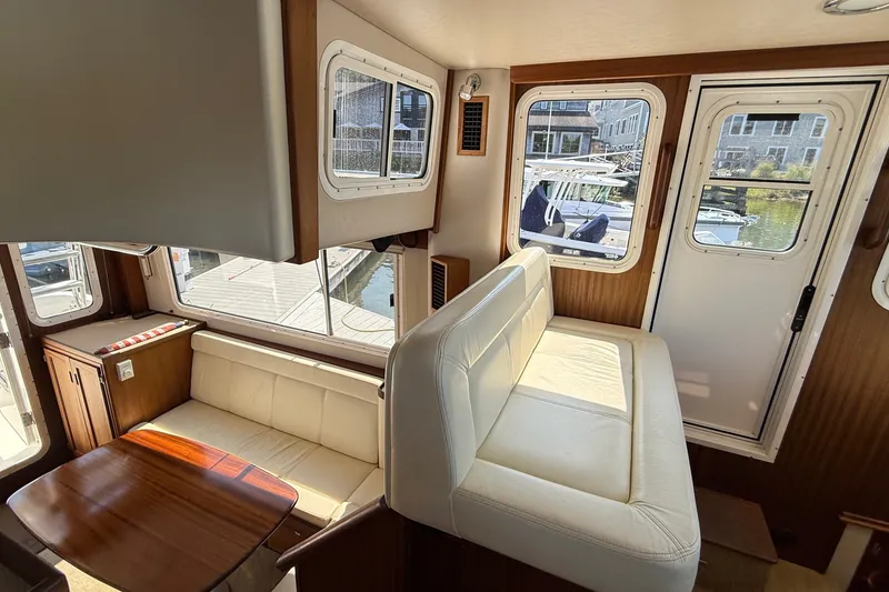 Slide: The Image of Interior of 2012 American Tug 365 with white seating and wooden accents. - 88