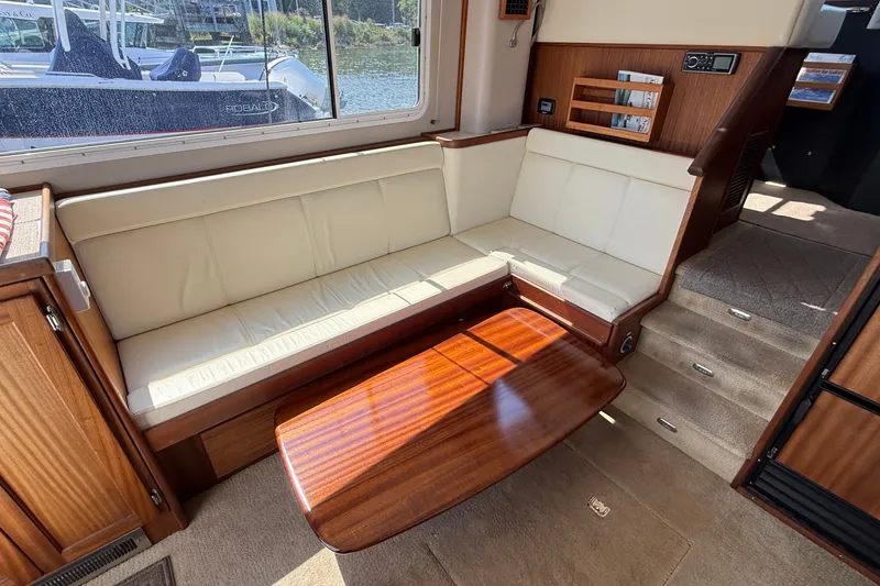 Slide: The Image of Interior of 2012 American Tug 365 with cream seating and wooden table. - 63