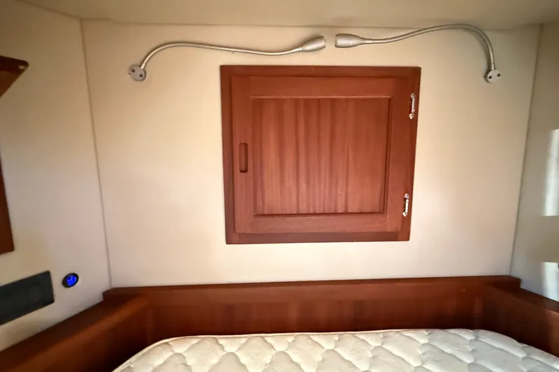 Slide: The Image of Interior cabin of 2012 American Tug 365 with wooden paneling and reading lights. - 124
