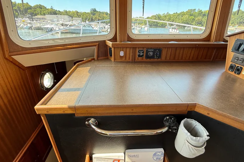 Slide: The Image of Interior view of a 2012 American Tug 365, showcasing the helm station with wood finish. - 106