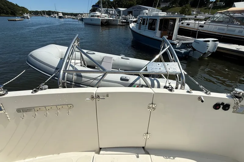 Slide: The Image of American Tug 365 (2012) with dinghy on davits, docked in a marina. - 37