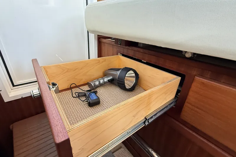 Slide: The Image of Open drawer in 2012 American Tug 365 with flashlight and charger inside. - 99