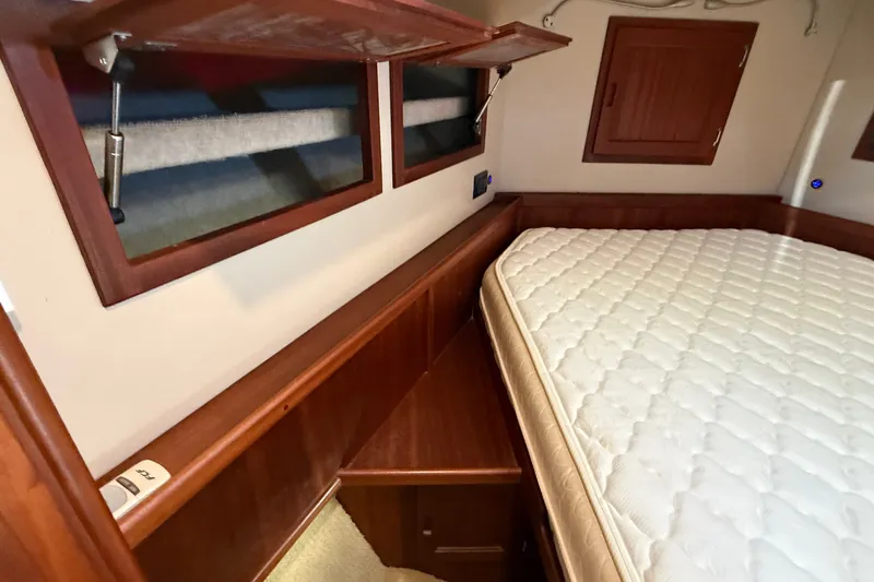 Slide: The Image of Cozy cabin interior of 2012 American Tug 365 with wooden accents and mattress. - 121