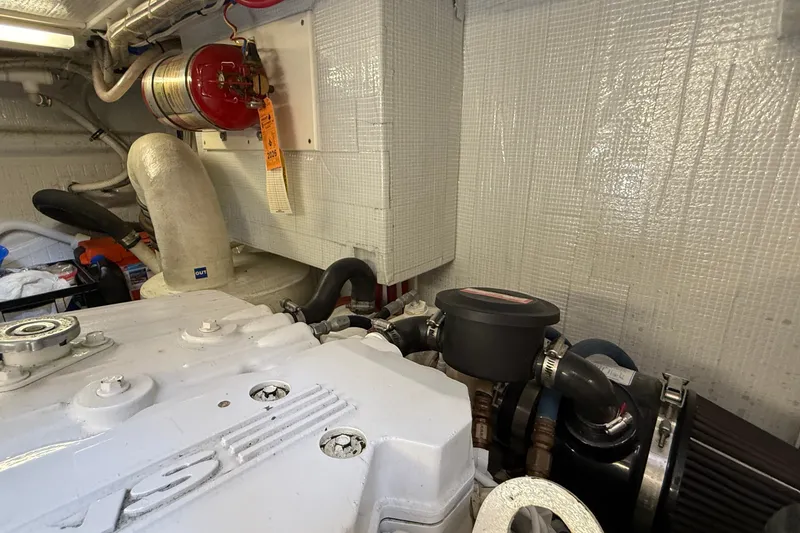 Slide: The Image of Engine room of a 2012 American Tug 365, featuring mechanical components and fire extinguisher. - 26