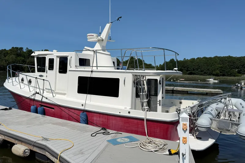 The Image of American Tug 365, 2012 model, docked with red hull and white cabin. - 0