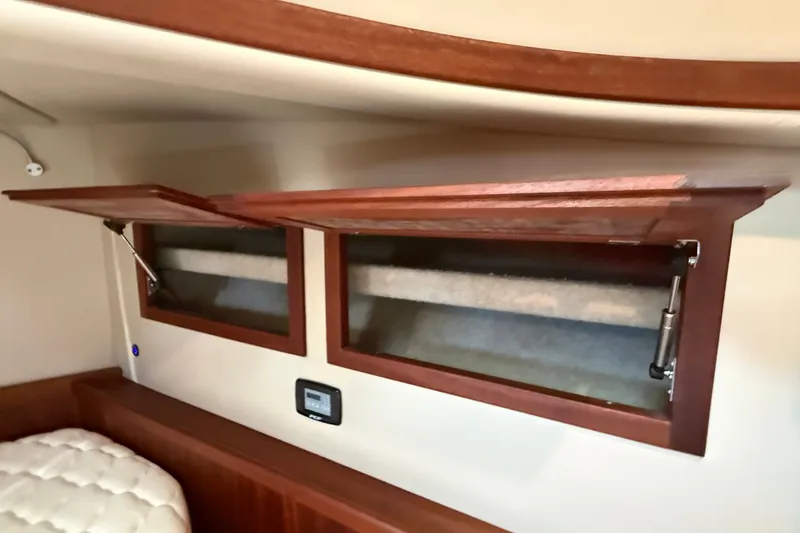 Slide: The Image of Interior of 2012 American Tug 365 with open wooden cabinets and control panel. - 120