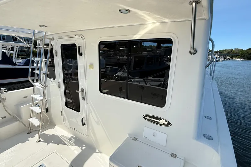 Slide: The Image of 2012 American Tug 365 boat exterior with ladder and door, docked by the water. - 46