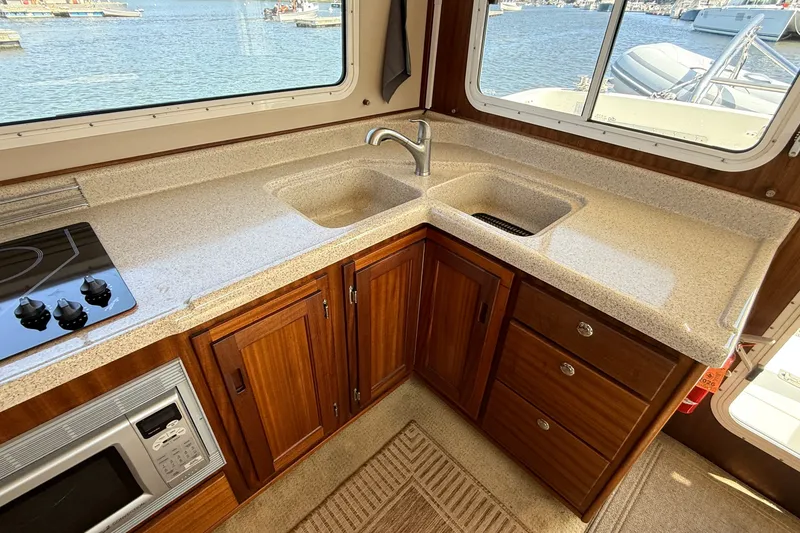 Slide: The Image of Cozy kitchen in 2012 American Tug 365 with wood cabinets and water view. - 57