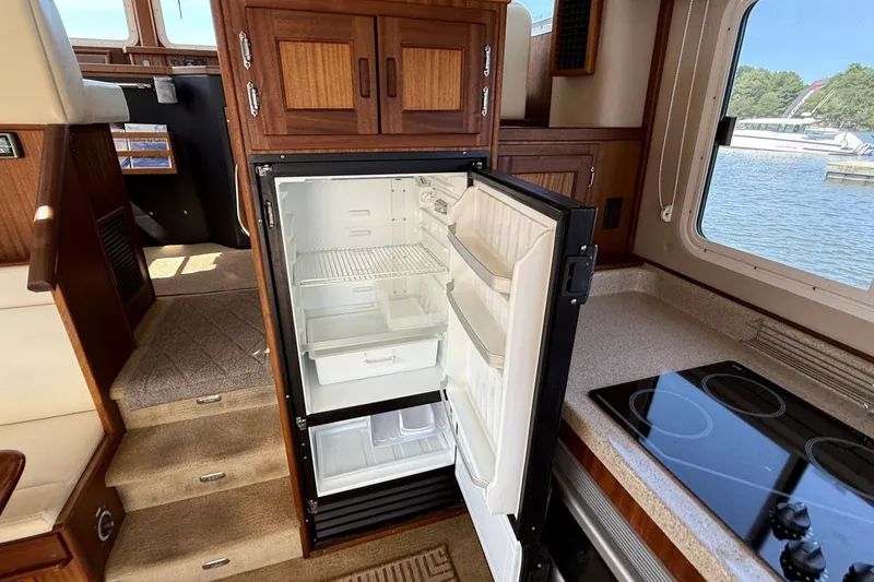Slide: The Image of Interior of 2012 American Tug 365 with open fridge and kitchen view. - 51