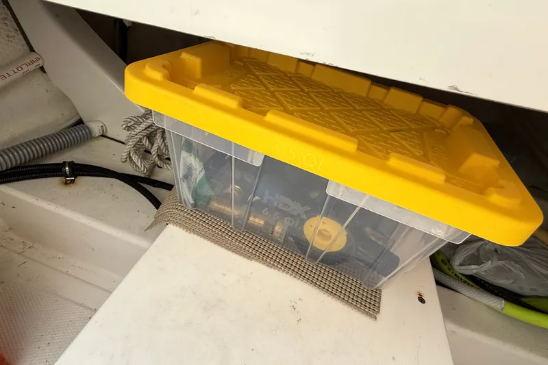 Slide: The Image of Storage box with yellow lid on American Tug 365, 2012 model, containing various items. - 44