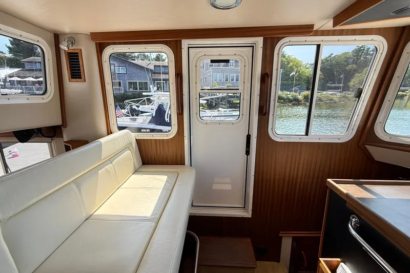 Slide: The Image of Interior of 2012 American Tug 365 with white seating and scenic window views. - 138