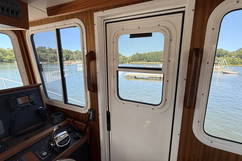 Slide: The Image of Interior view of 2012 American Tug 365, showcasing helm and scenic waterway. - 89