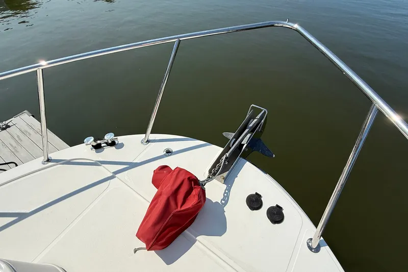 Slide: The Image of Bow of a 2012 American Tug 365 with anchor and red cover on calm water. - 7