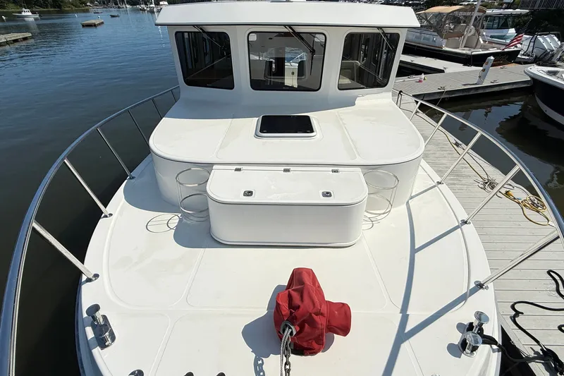Slide: The Image of 2012 American Tug 365 boat docked, showcasing spacious deck and cabin windows. - 4