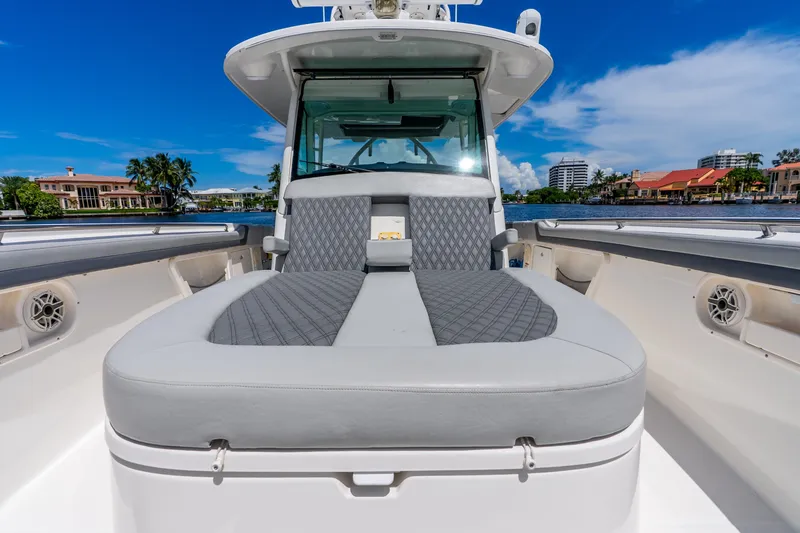 Slide: The Image of 2011 Boston Whaler 370 Outrage boat with cushioned seating, docked by waterfront homes. - 50
