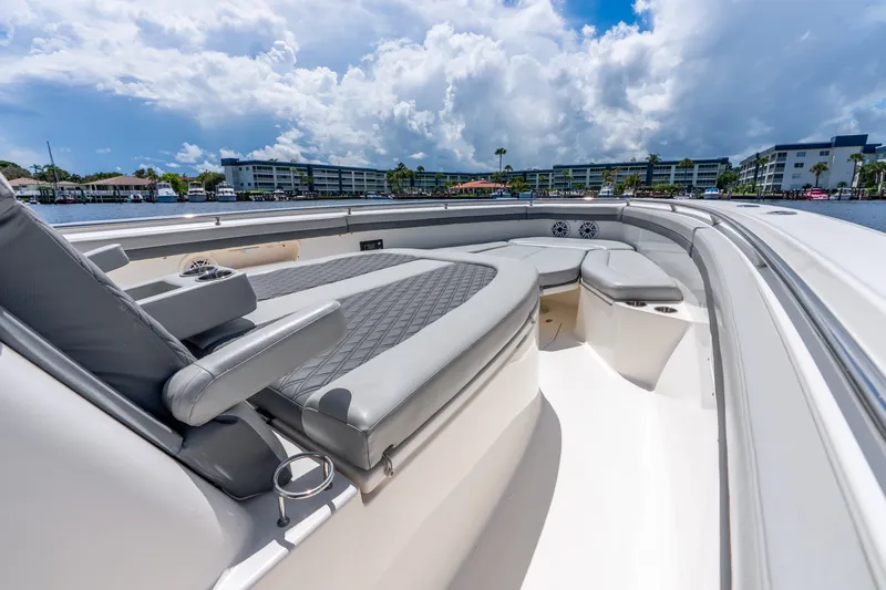 Slide: The Image of 2011 Boston Whaler 370 Outrage boat interior with cushioned seating and waterfront view. - 45