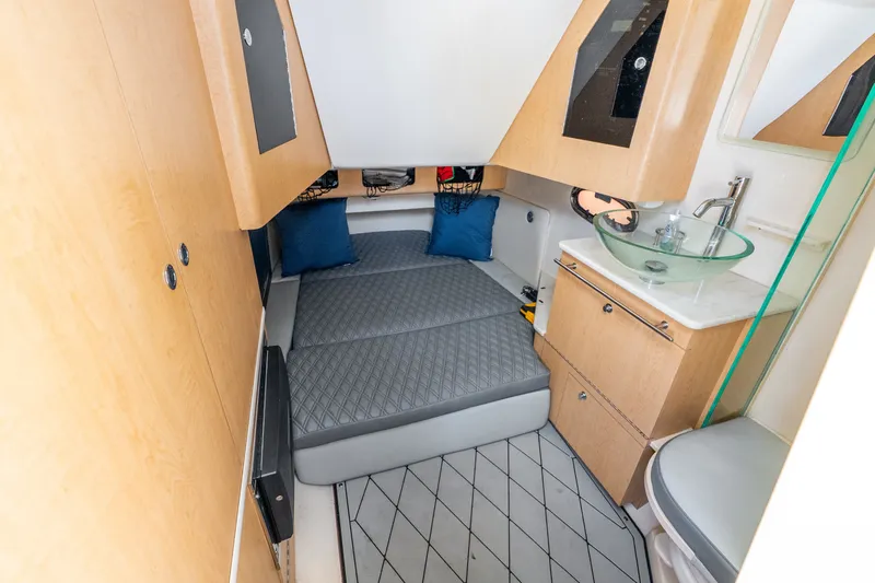 Slide: The Image of 2011 Boston Whaler 370 Outrage cabin interior with bed, sink, and storage. - 44