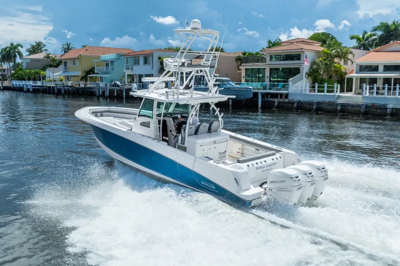 Slide: The Image of 2011 Boston Whaler 370 Outrage cruising on a scenic waterfront with luxury homes. - 13