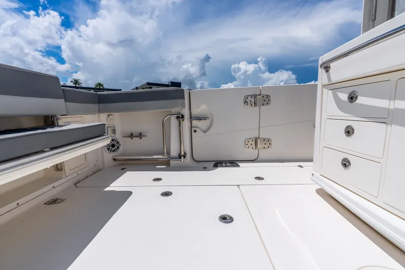 Slide: The Image of 2011 Boston Whaler 370 Outrage deck with seating and storage under a blue sky. - 21