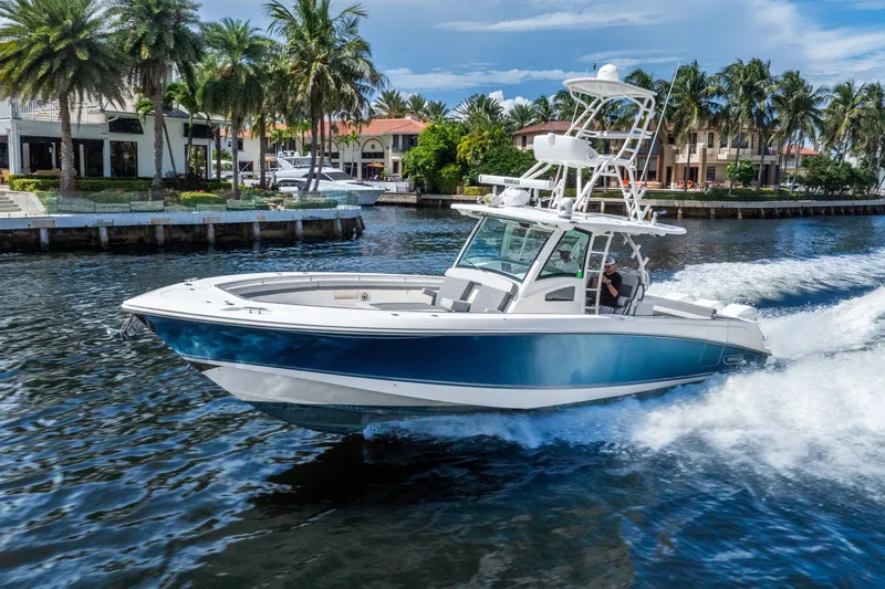Slide: The Image of 2011 Boston Whaler 370 Outrage cruising on a scenic waterway with palm trees. - 16