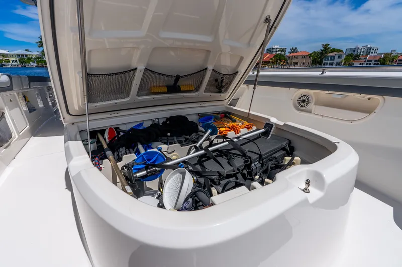Slide: The Image of Open storage compartment on 2011 Boston Whaler 370 Outrage boat, filled with various gear. - 51
