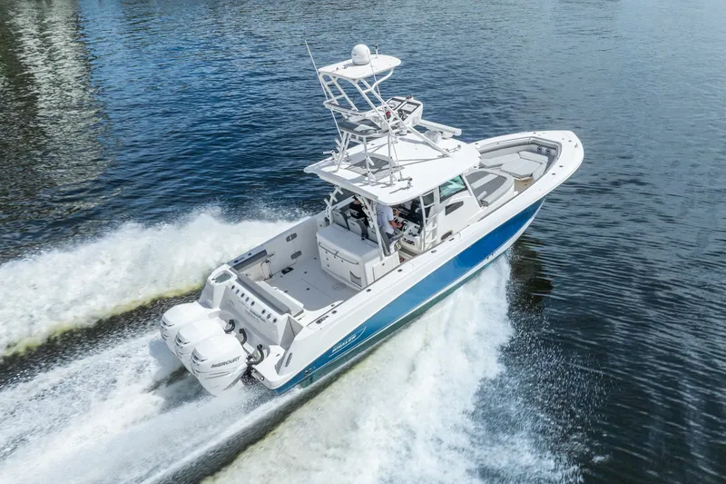 Slide: The Image of 2011 Boston Whaler 370 Outrage cruising on water, showcasing sleek design and powerful engines. - 19