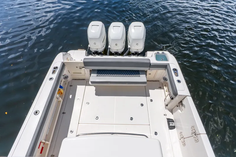 Slide: The Image of 2011 Boston Whaler 370 Outrage boat with triple engines, spacious deck, and seating area. - 36