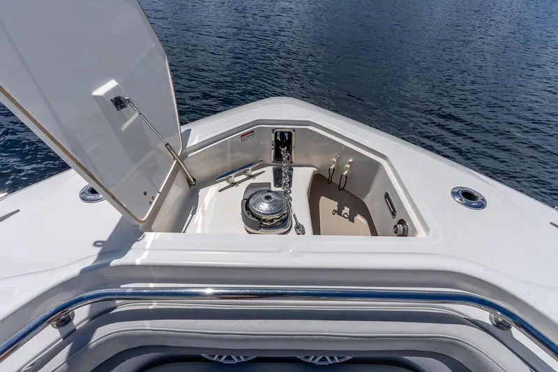 Slide: The Image of 2011 Boston Whaler 370 Outrage anchor compartment with open hatch on calm water. - 47