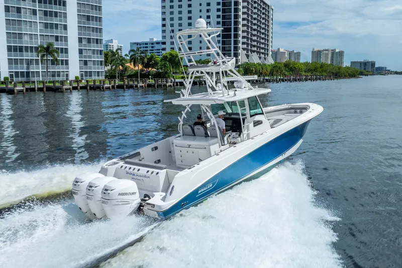 Slide: The Image of 2011 Boston Whaler 370 Outrage cruising near waterfront buildings. - 18