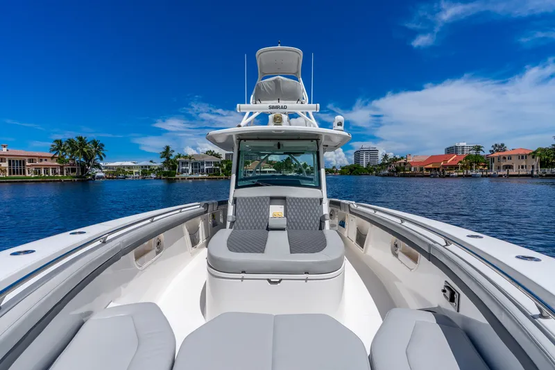 Slide: The Image of 2011 Boston Whaler 370 Outrage boat on a scenic waterfront with clear blue skies. - 48