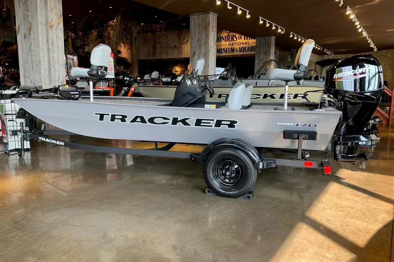 The Image of 2027 Tracker Pro 170 boat displayed indoors with Mercury engine. - 0