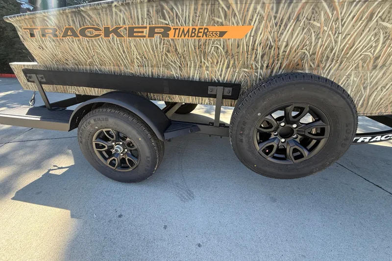 Slide: The Image of 2027 Tracker Grizzly 1553 Timber trailer with camouflage design and black alloy wheels. - 17