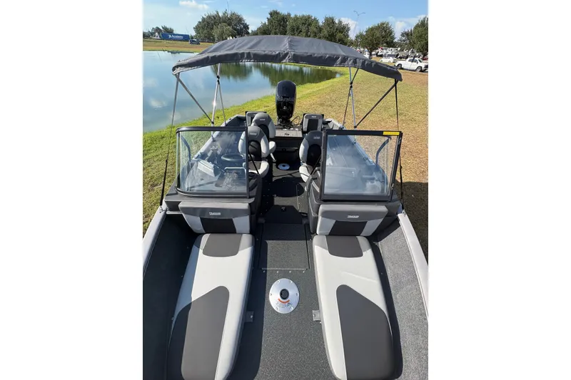 Slide: The Image of 2027 Tracker Pro Guide V-175 Combo boat with seating and canopy, near a pond. - 27