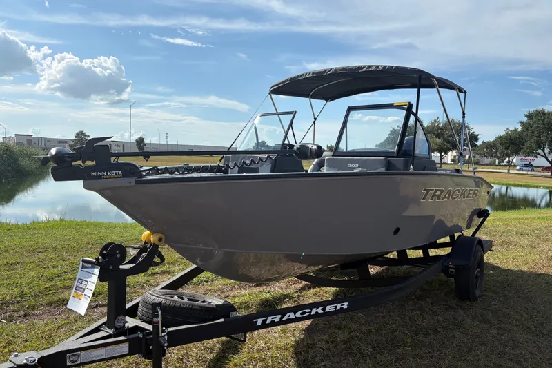 Slide: The Image of 2027 Tracker Pro Guide V-175 Combo boat on trailer by a lake under a blue sky. - 20