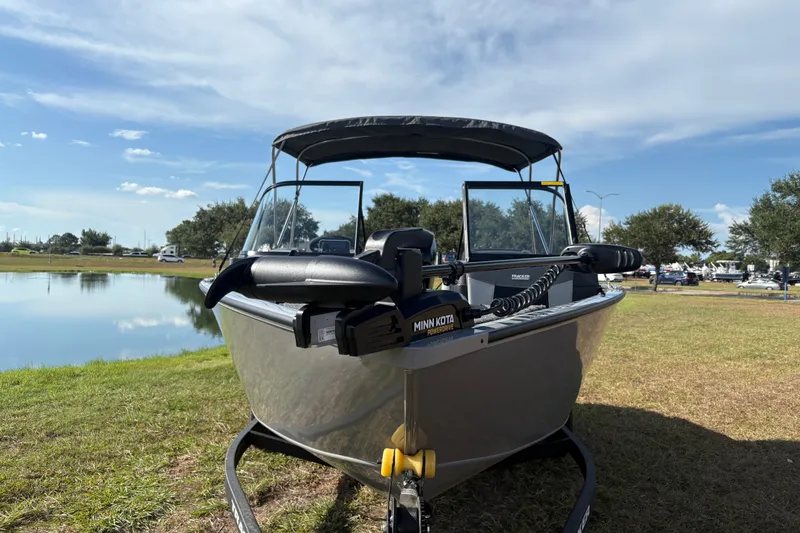 Slide: The Image of 2027 Tracker Pro Guide V-175 Combo boat by a serene lake under a clear sky. - 19