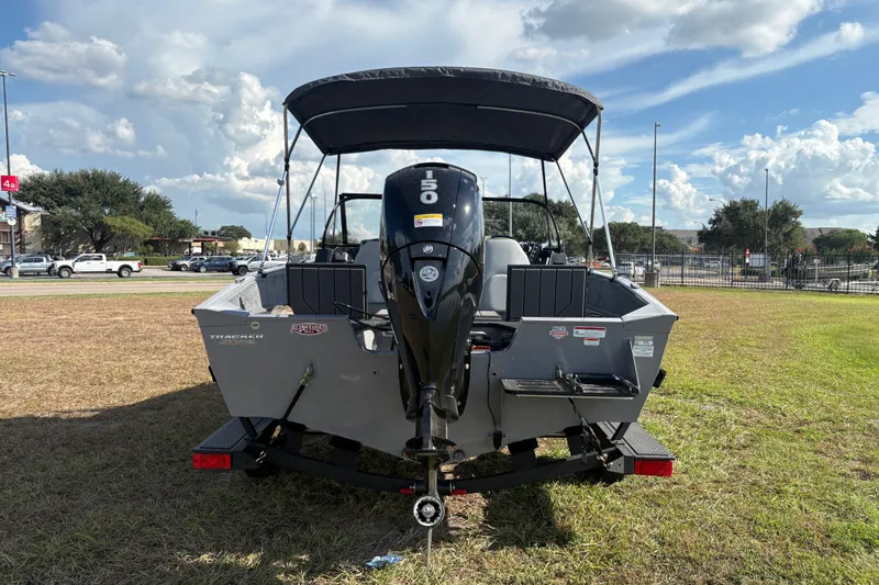 Slide: The Image of 2027 Tracker Pro Guide V-175 Combo boat with 150 HP engine, parked on grass under a blue sky. - 23