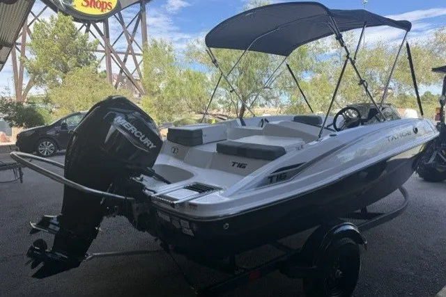 Slide: The Image of 2027 Tahoe T16 boat with Mercury engine, parked outdoors under canopy. - 2