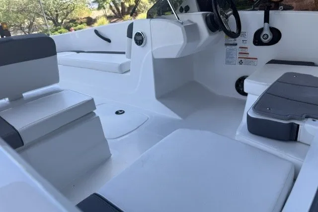 Slide: The Image of 2027 Tahoe T16 boat interior with white and gray seating, steering wheel, and console. - 9