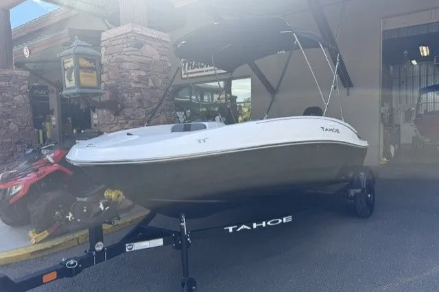 Slide: The Image of 2027 Tahoe T16 boat on trailer, parked outside a building with stone accents. - 1