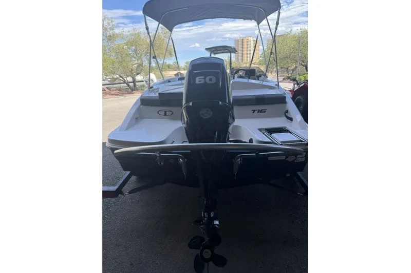 Slide: The Image of 2027 Tahoe T16 boat with 60 HP engine, parked outdoors under a canopy. - 5