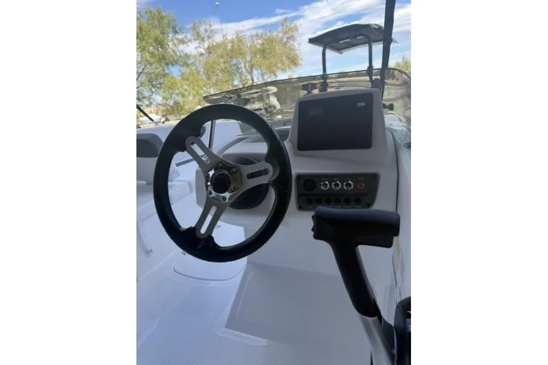 Slide: The Image of Steering wheel and dashboard of 2027 Tahoe T16 boat under clear sky. - 7
