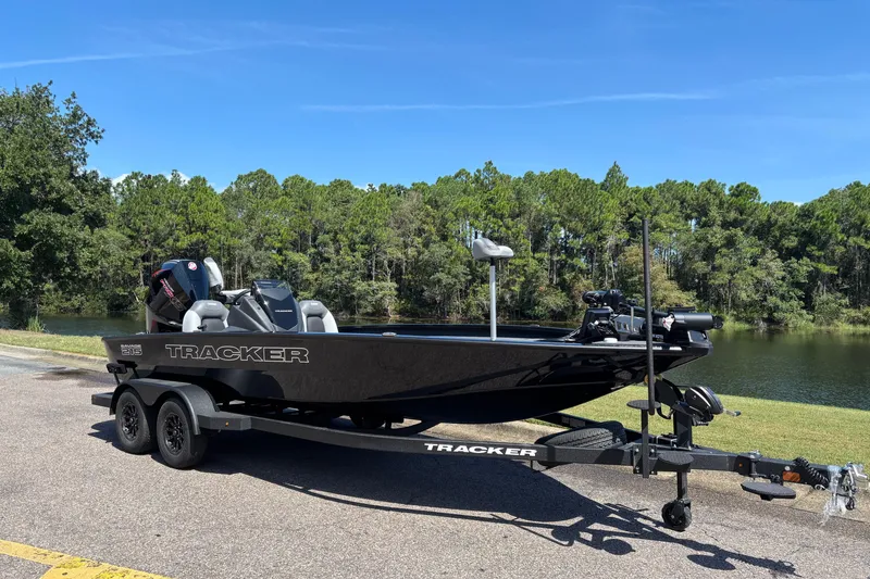 The Image of 2027 Tracker Savage 215 boat on trailer by a scenic lake. - 0
